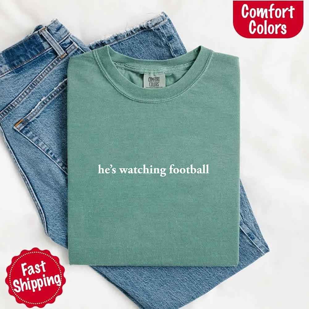 He’s Watching Football Tee - Comfort Colors Funny Shirt for Her