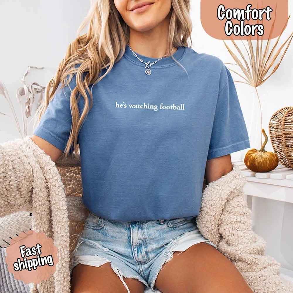 He’s Watching Football Tee - Comfort Colors Funny Shirt for Her